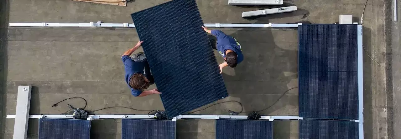 Techniciens transportant des panneaux solaires