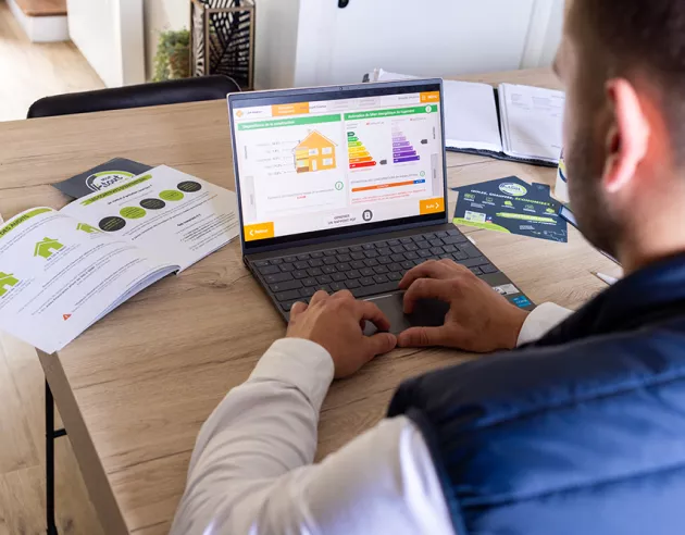 Un homme réalisant un diagnostic logement sur son ordinateur portable